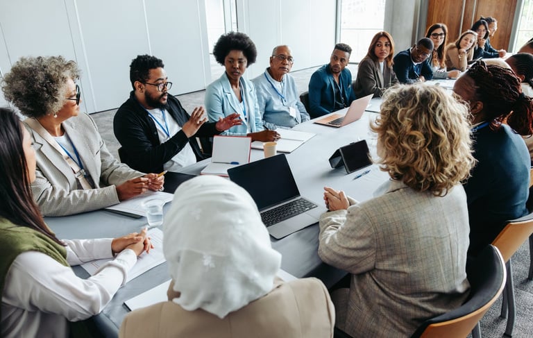Multiethnic group of professionals engaged in strategy and brainstorming session around a conference table